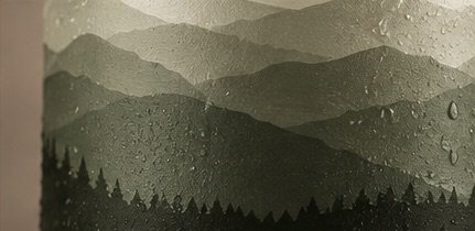 Close-up of the can's layered mountain and pine forest artwork.